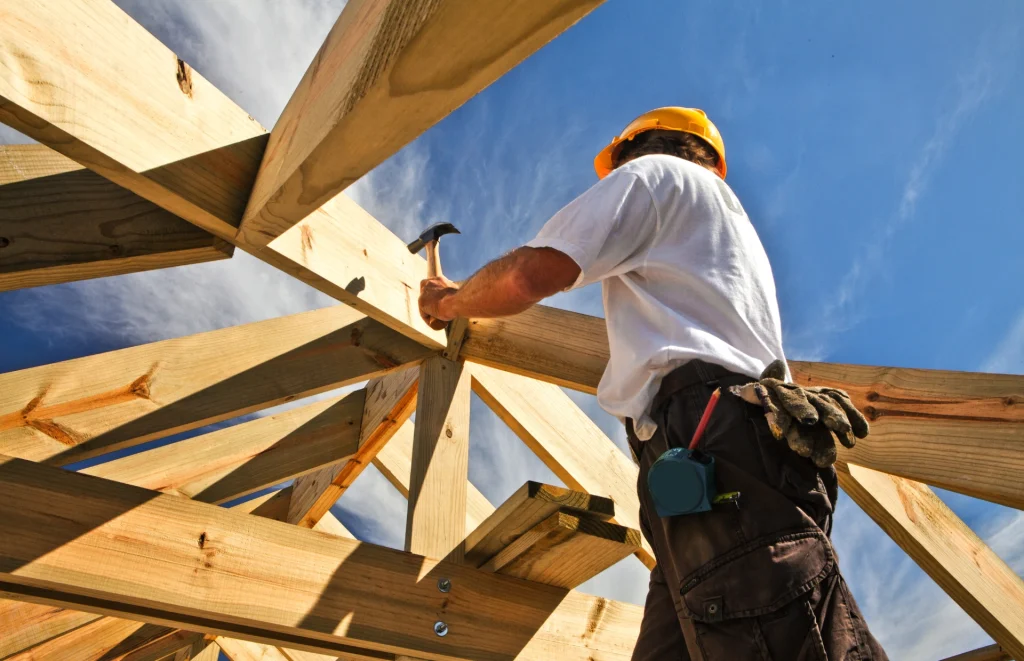 roofer worker builder working on roof structure at construction site